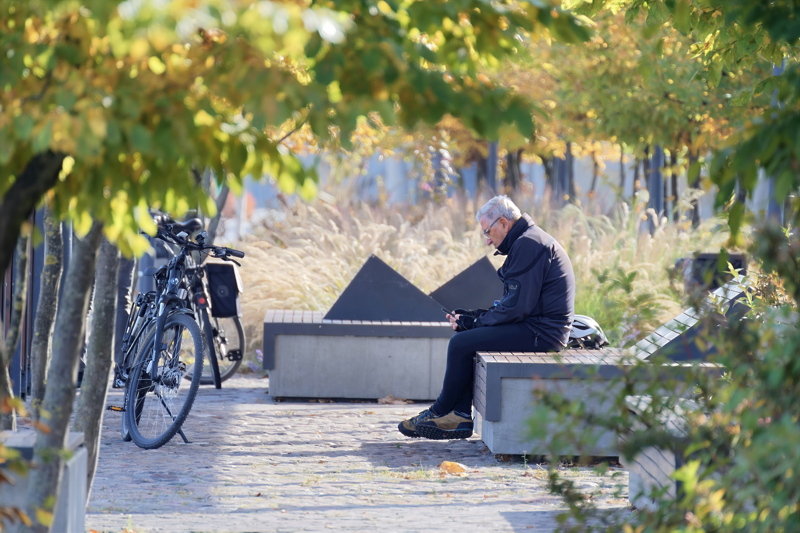 21 - An adult person sitting on a modern urban bench in Warsaw